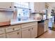 Sunlit kitchen featuring white cabinets, subway tile backsplash, a vintage-style sink, and stainless steel appliances at 566 Wagon Wheel Climb, Lawrenceville, GA 30044