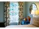 Bright bedroom featuring large window with patterned drapes, a mirror and a dresser, creating a relaxing space at 566 Wagon Wheel Climb, Lawrenceville, GA 30044