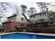 Backyard view of a gunite pool with concrete decking and an exposed brick home addition at 566 Wagon Wheel Climb, Lawrenceville, GA 30044