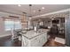 Eat-in kitchen shows granite island, stainless sink, industrial pendant lights, and dining area for Gathering meals at 58 Ashbury Cir, Dallas, GA 30157