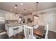 Charming eat-in kitchen featuring pendant lighting, island with seating, pantry doors, and modern appliances at 58 Ashbury Cir, Dallas, GA 30157