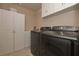 Laundry room featuring front-load washer and dryer, storage cabinets, and neutral walls at 58 Ashbury Cir, Dallas, GA 30157