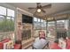 Enclosed patio with stone fireplace, ceiling fan, and cushioned wicker furniture at 58 Ashbury Cir, Dallas, GA 30157