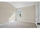 A bright, carpeted bedroom with natural light from the window and a clean, minimalist aesthetic at 5995 Spring Way, Stonecrest, GA 30038
