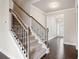 Staircase with carpet, hardwood floors, and wrought iron spindles leading to the upper level at 5995 Spring Way, Stonecrest, GA 30038
