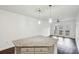 Modern kitchen island with granite countertop and stylish pendant lighting near living area with balcony access at 840 United Se Ave # 411, Atlanta, GA 30312