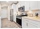 Well-lit kitchen with stainless steel appliances, quartz countertops, and sleek white cabinets at 126 Maple Creek Way, Woodstock, GA 30188