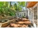 Brick back patio with seating and fire pit surrounded by lush trees at 135 River Ne Lndg, Sandy Springs, GA 30350