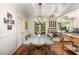 Dining room with hardwood floors, white ceiling beams, long wooden table, and kitchen access at 135 River Ne Lndg, Sandy Springs, GA 30350