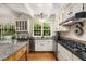 Cozy kitchen features white cabinetry, granite counters, stainless steel appliances, and a vintage wooden island at 135 River Ne Lndg, Sandy Springs, GA 30350