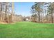 Large backyard that features a well kept green lawn with trees in the distance at 602 Sandhill Hickory Level Rd, Carrollton, GA 30116