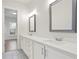 Bathroom with double vanity, white cabinetry, framed mirrors, and tile floors at 602 Sandhill Hickory Level Rd, Carrollton, GA 30116
