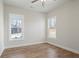 Bedroom with hardwood flooring, two windows and a ceiling fan providing a cozy atmosphere at 602 Sandhill Hickory Level Rd, Carrollton, GA 30116