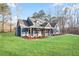 Angle view of the craftsman-style home, showing its blue siding, stone accents, covered porch, and well-manicured lawn at 602 Sandhill Hickory Level Rd, Carrollton, GA 30116