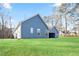 Exterior side view of the house with a lush green lawn and tall trees under a blue sky at 602 Sandhill Hickory Level Rd, Carrollton, GA 30116