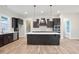 A spacious kitchen features dark cabinets, stainless appliances, a central island, and pendant lighting at 602 Sandhill Hickory Level Rd, Carrollton, GA 30116