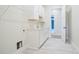 Bright laundry room features white cabinetry, light countertops, tile floors, and utility sink at 602 Sandhill Hickory Level Rd, Carrollton, GA 30116