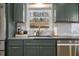 Close up of kitchen sink area, granite countertops and green cabinets at 665 Lake Charles Way, Roswell, GA 30075