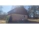 Angle view of the back exterior of the home with brick facade and siding. A door allows access to the backyard at 3747 Southland Ct, Atlanta, GA 30344