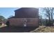 Back exterior of the property featuring a brick facade, siding, small door and electrical lines visible above at 3747 Southland Ct, Atlanta, GA 30344