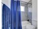 Neutral bathroom featuring a shower with gray tiles and a blue curtain at 6700 Roswell Rd # 32C, Atlanta, GA 30328