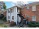 View of a brick and siding townhome with a black metal staircase leading to the second level entrance at 6700 Roswell Rd # 32C, Atlanta, GA 30328