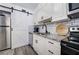 Updated kitchen with granite countertops, stainless steel appliances, and a stylish barn door at 6700 Roswell Rd # 32C, Atlanta, GA 30328