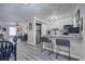 Open-concept living space with breakfast bar, modern lighting, and wood-look flooring throughout at 6700 Roswell Rd # 32C, Atlanta, GA 30328