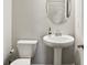 Modern bathroom with a pedestal sink, toilet, and neutral decor at 709 Bismark Ne Rd, Atlanta, GA 30324