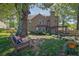Shaded backyard with a swing under a large tree, views of the home, and lovely landscaping at 2295 Hemrick Rd, Cumming, GA 30041