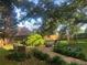 This backyard has a stone walkway, mature trees, and a covered outdoor space with comfortable seating at 2295 Hemrick Rd, Cumming, GA 30041