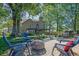Paver patio featuring outdoor seating, a fire pit, mature trees, and a view of the home at 2295 Hemrick Rd, Cumming, GA 30041