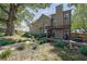 Large, fenced backyard featuring an outdoor kitchen area with seating, mature trees, and lush lawn at 2295 Hemrick Rd, Cumming, GA 30041