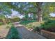 Serene backyard featuring a stone walkway, mature trees, and lush landscaping at 2295 Hemrick Rd, Cumming, GA 30041