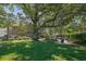 Large backyard featuring mature trees, a patio area, and an outdoor swing at 2295 Hemrick Rd, Cumming, GA 30041