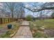 Large backyard with mature trees, stone walkway, fire pit, and plenty of space for outdoor activities at 2295 Hemrick Rd, Cumming, GA 30041