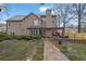 The rear exterior of the home has a patio, stone walkway, and a spacious backyard with mature trees at 2295 Hemrick Rd, Cumming, GA 30041