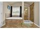 The main bathroom includes a soaking tub, a glass shower enclosure and tile flooring at 2295 Hemrick Rd, Cumming, GA 30041