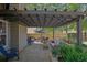 Outdoor patio under pergola with dining set, lounge seating, and well-manicured landscaping at 2295 Hemrick Rd, Cumming, GA 30041