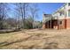 Spacious backyard with mature trees, grassy area, and deck offering a serene view of the wooded landscape at 9470 Dominion Way, Alpharetta, GA 30022