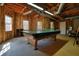Unfinished basement featuring exposed wood framing, a vintage ping pong table, and multiple windows for natural light at 9470 Dominion Way, Alpharetta, GA 30022