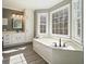 Bright bathroom features a soaking tub, white cabinets and grey walls at 9470 Dominion Way, Alpharetta, GA 30022