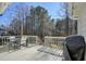 Outdoor wooden deck perfect for entertaining, with a dining table, seating, a grill and views of wooded backyard at 9470 Dominion Way, Alpharetta, GA 30022
