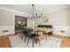 A modern dining room featuring a long wooden table, black chairs, and stylish lighting at 9470 Dominion Way, Alpharetta, GA 30022