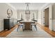 Dining area with a long wooden table, modern black chairs, and striking chandelier at 9470 Dominion Way, Alpharetta, GA 30022