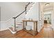 Elegant foyer featuring hardwood floors, a staircase with black and white railings, and wainscoting at 9470 Dominion Way, Alpharetta, GA 30022