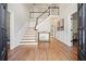 Elegant foyer featuring hardwood floors, a staircase with black and white railings, and wainscoting at 9470 Dominion Way, Alpharetta, GA 30022