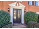 Elegant double front door with sidelights and decorative trim, flanked by manicured shrubs at 9470 Dominion Way, Alpharetta, GA 30022