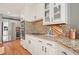 Kitchen with granite counters, stainless steel appliances, glass-front cabinets and hardwood floors, and backsplash at 9470 Dominion Way, Alpharetta, GA 30022