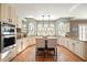 Bright kitchen with white cabinetry, granite counters, stainless steel appliances, and a central island with seating at 9470 Dominion Way, Alpharetta, GA 30022
